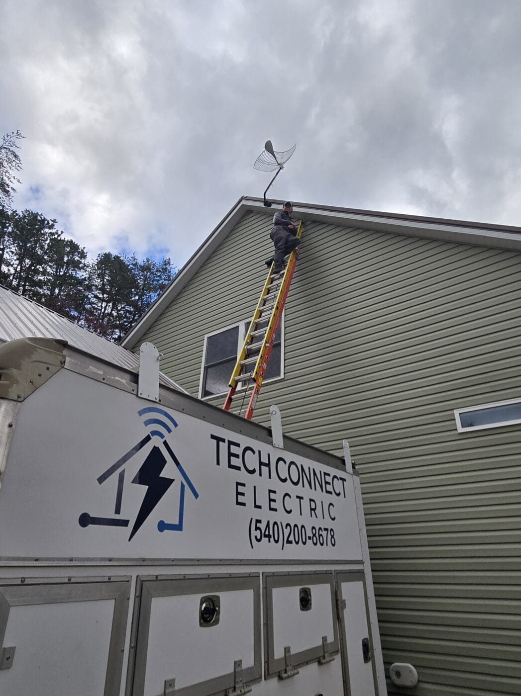 A worker on a tall ladder installs a satellite dish on the roof of a house; below, a Tech Connect Electric van offers smart home & business integration services.